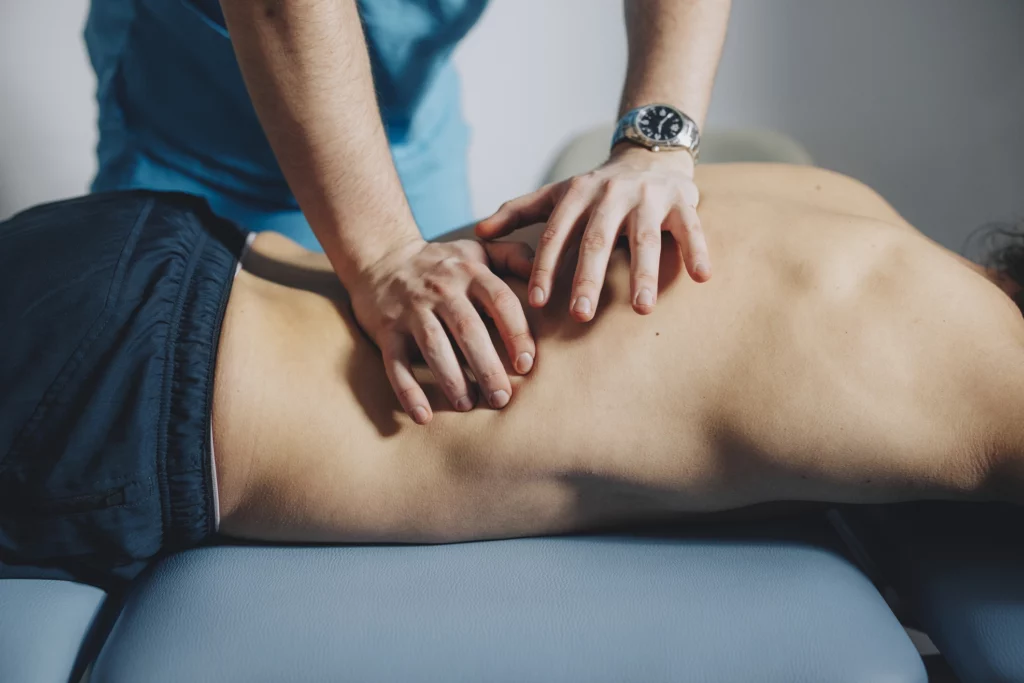 A man is getting a home massage on his back.