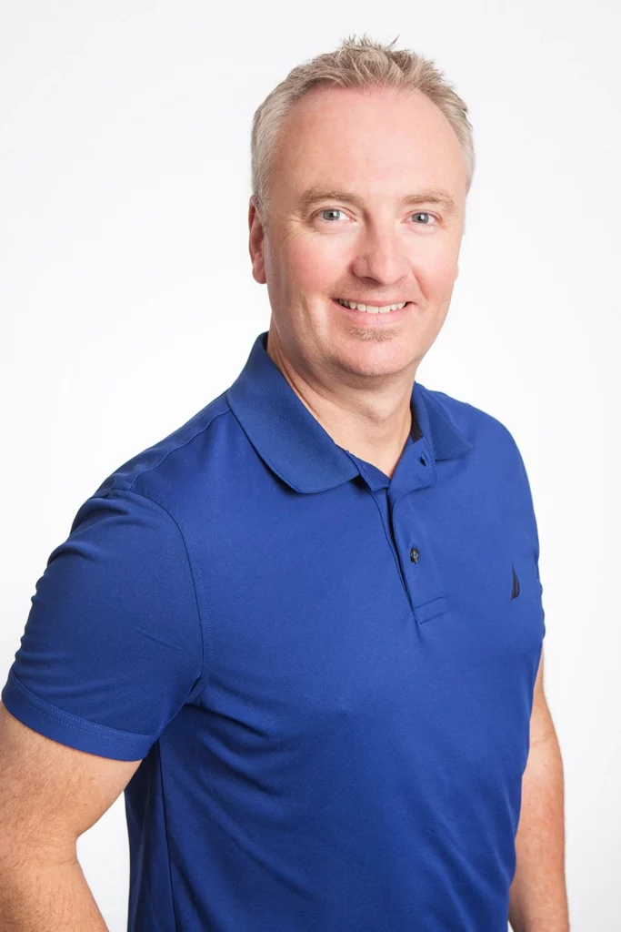 Dr. Robert Cumming in a blue shirt posing for a photo.