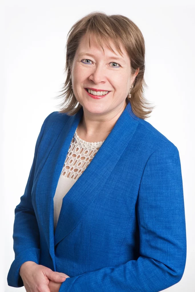 Dr. Jennifer Harrison in a blue suit is posing for a photo.