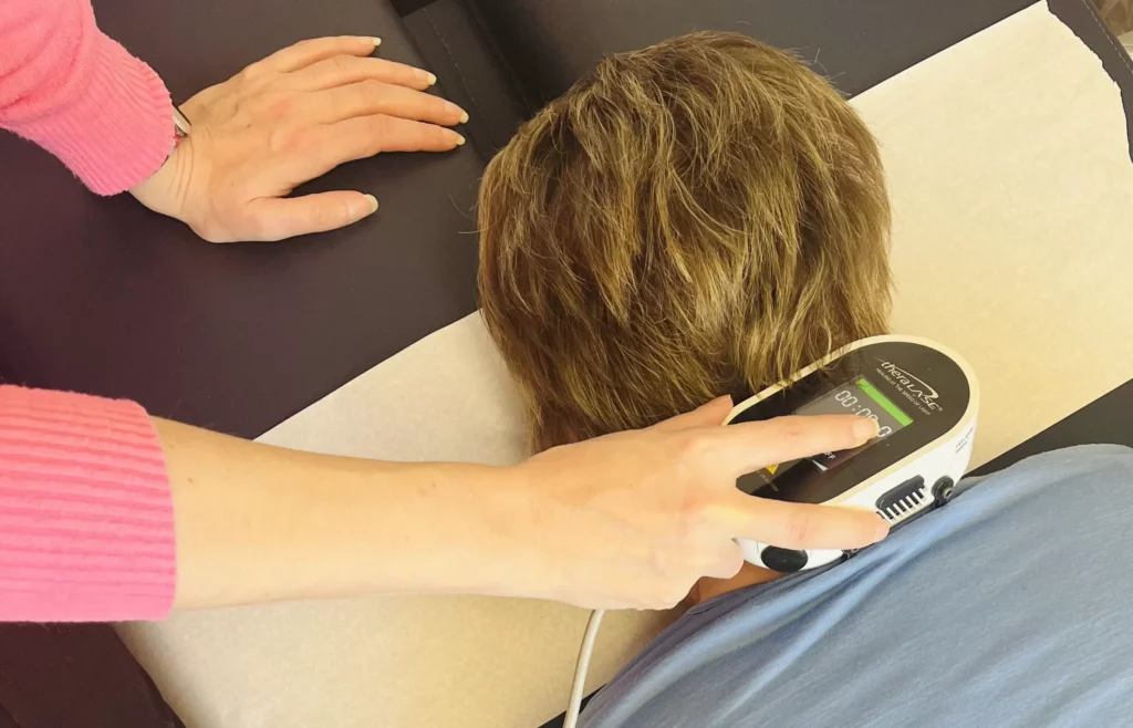 A person is receiving a massage using laser therapy.