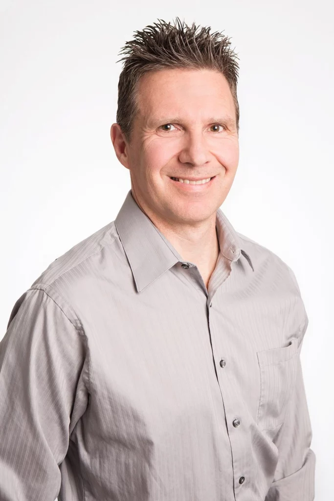 Steve Ernst in a gray shirt smiling for the camera massage therapy South Calgary.