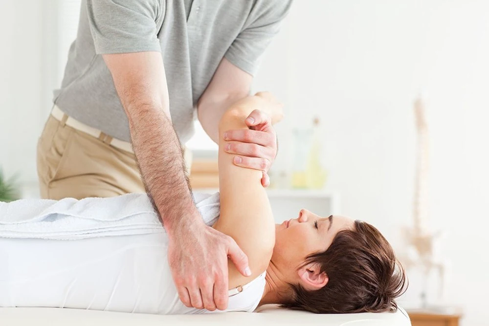 A woman is being massaged by a chiropractor.
