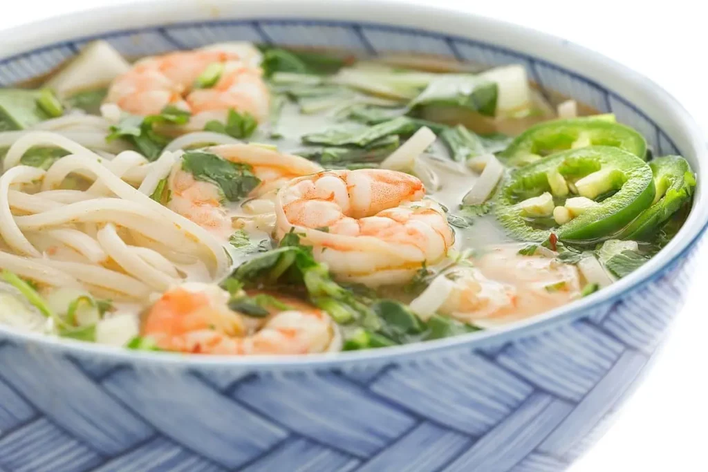 A bowl of asian shrimp noodle soup.