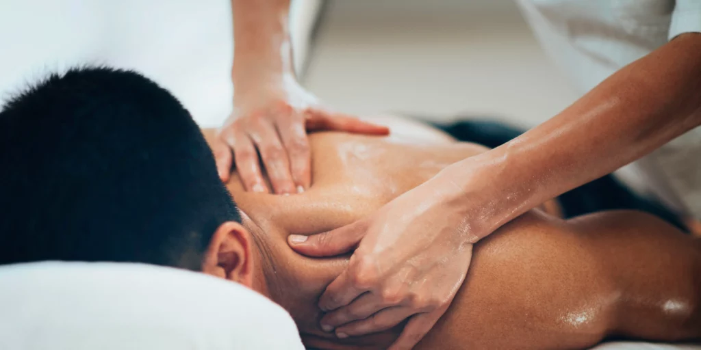 A man getting a back massage at a spa laying face down massage South Calgary.