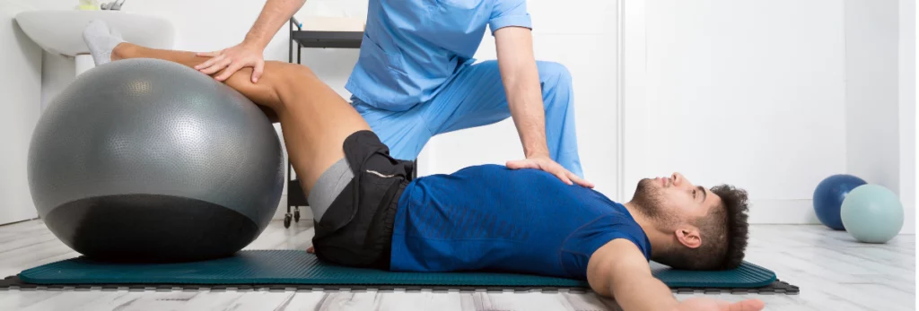 A man is receiving pelvic floor therapy on an exercise ball.